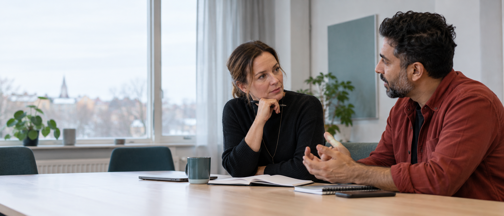 En chef och en medarbetare i ett fokuserat samtal på en arbetsplats